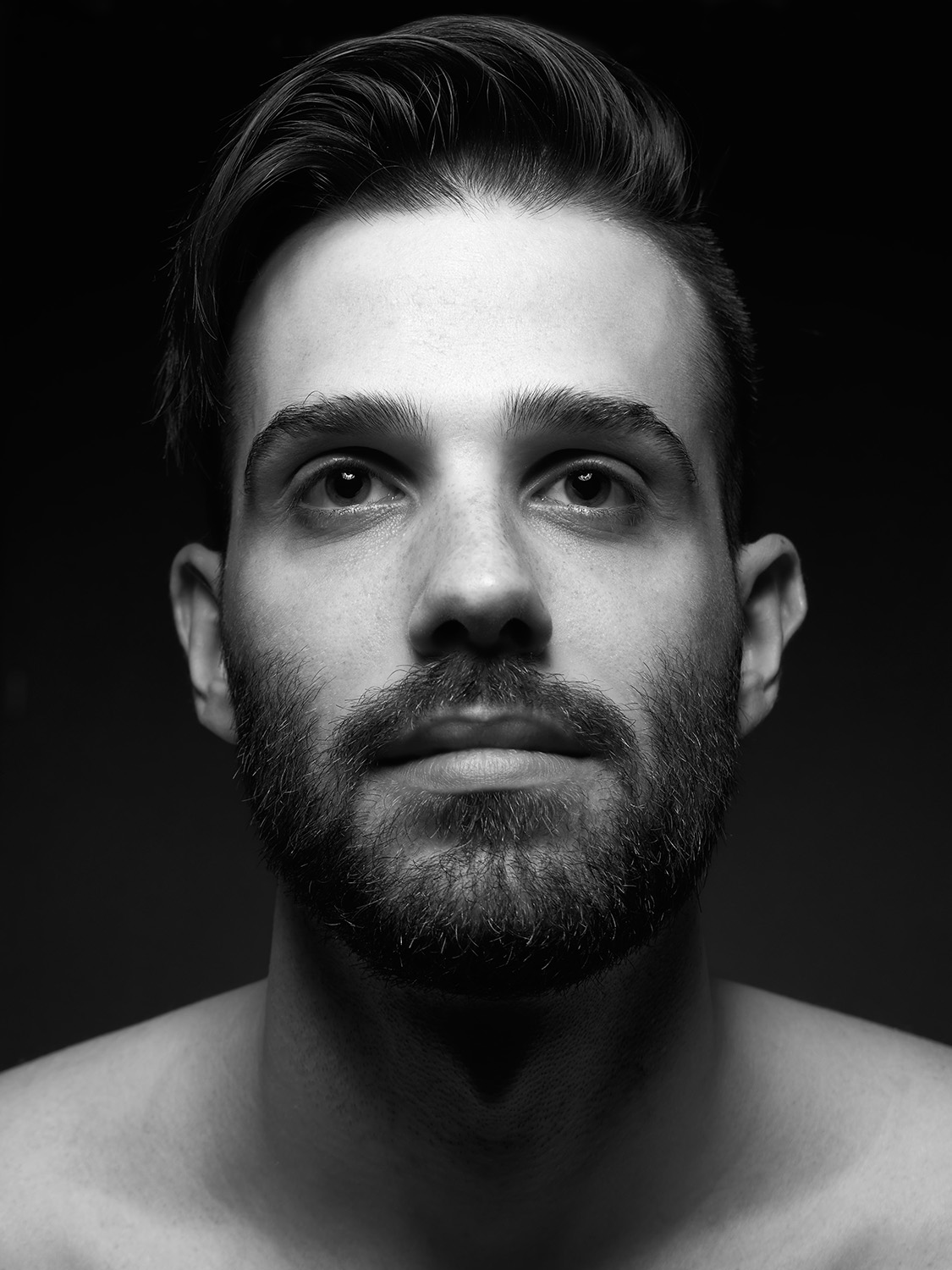 Ritratto in bianco e nero di un uomo con la barba, in primo piano